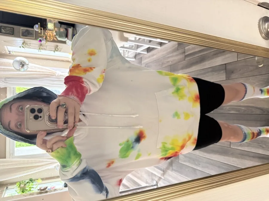 Nat in the mirror in the HIVE tie-dye hoodie, with matching tie-dye socks